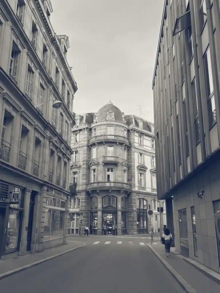 Rue bordée d’immeubles en pierre de taille menant à un immeuble d’angle coiffé d’un dôme : l’actualité sur la fiscalité immobilière décryptée par Pierre Fiscale